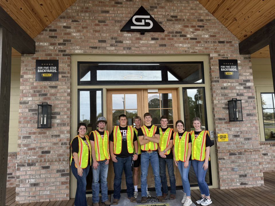 Students in high-visibility vests at a job site