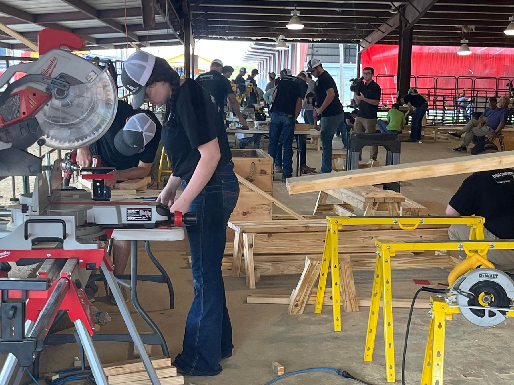Student cutting lumber at a miter saw