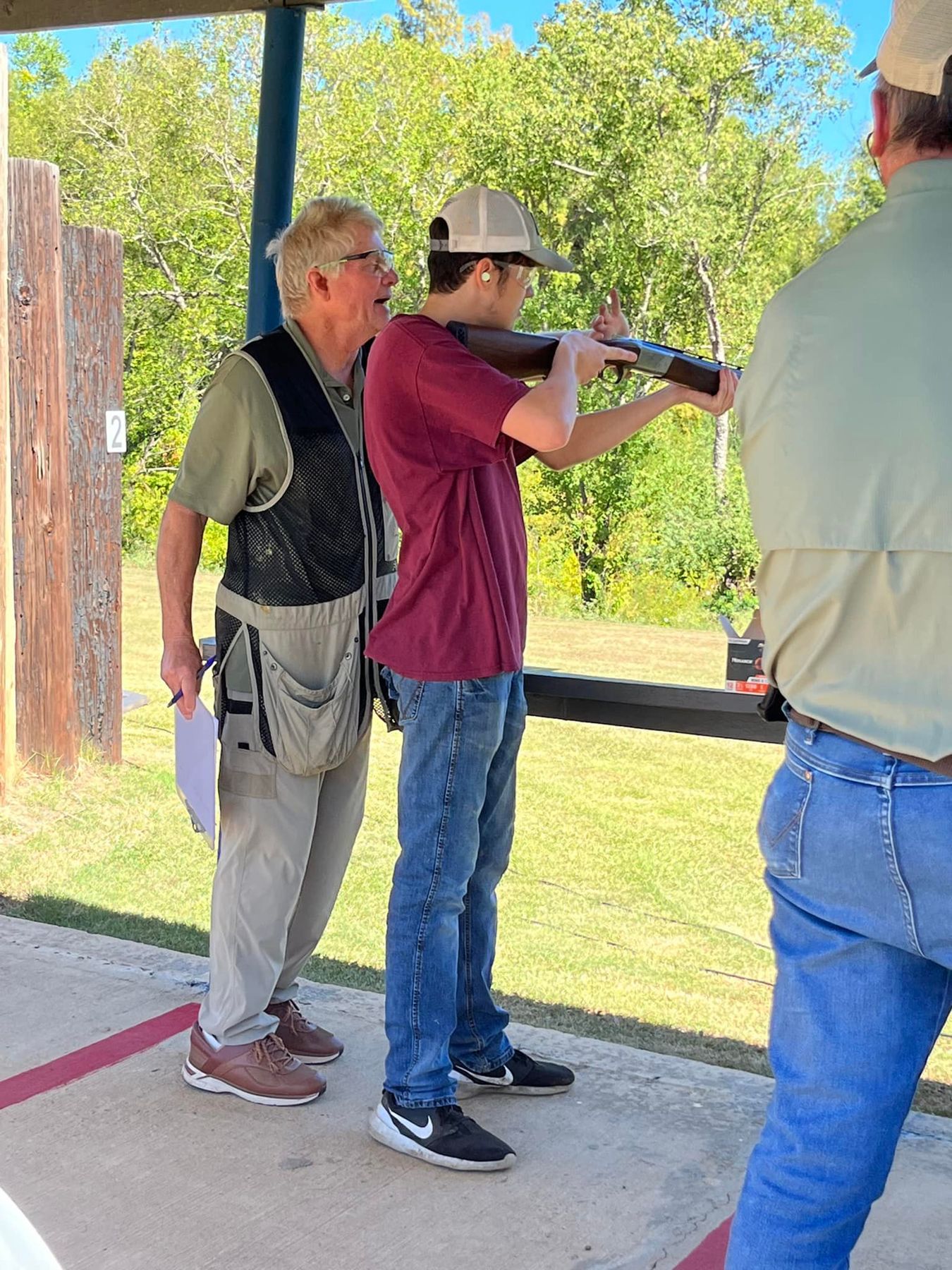 A student shooting with a range volunteer