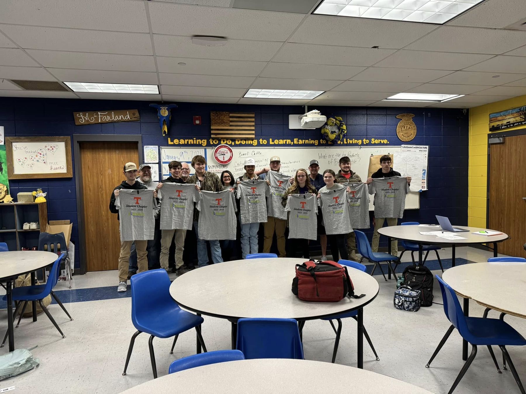Chapter members with their new shirts in a classroom